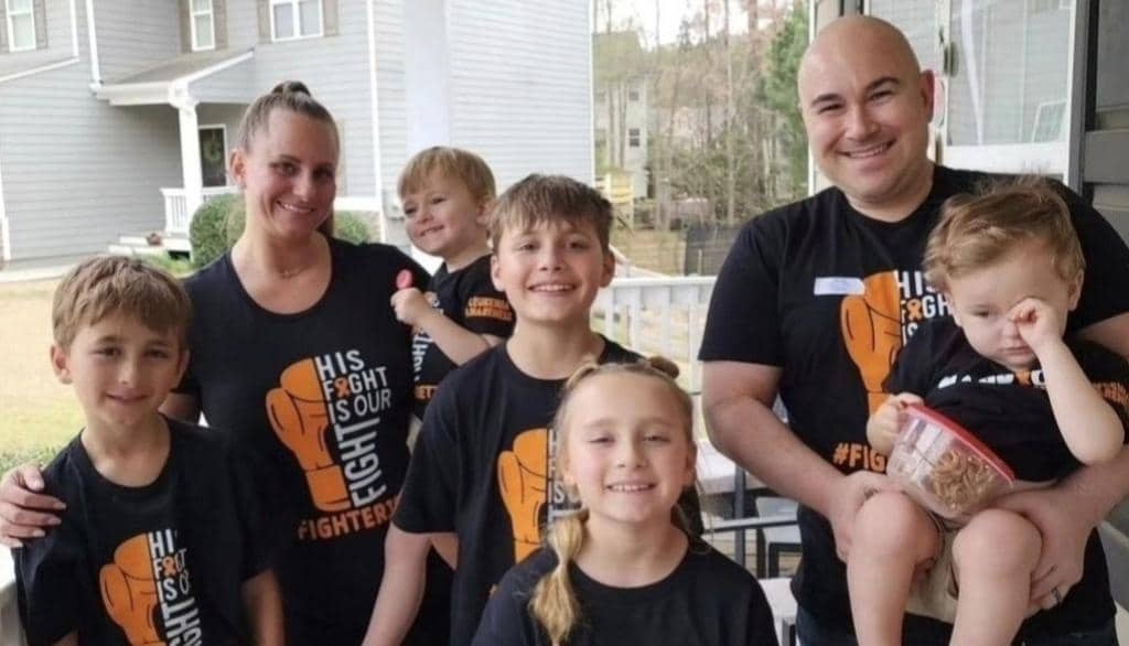 Jon Sharkey with his wife and children wearing fighter jet shirts in support of Jett’s leukemia battle