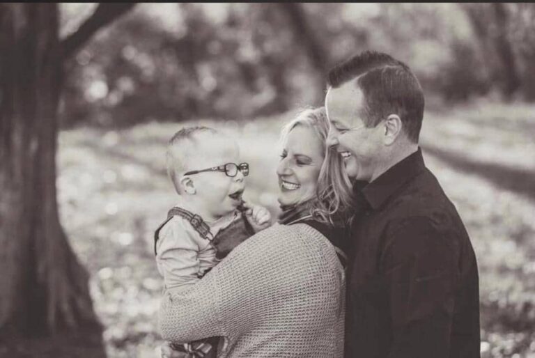 Tim McNutt smiling with his wife Amber and son Elijah, embraced in a moment of joy and strength.